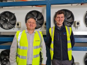 Pcc employees in front of an air conditioning unit